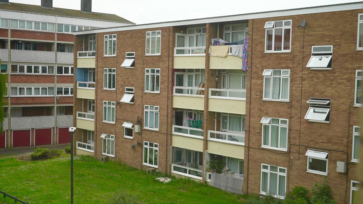 A block of flats with a grass front garden