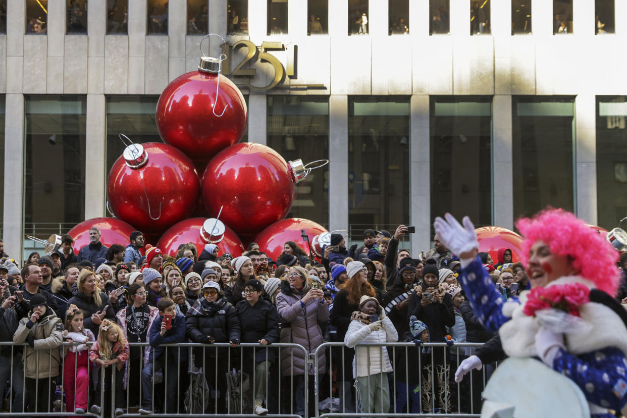 Spectators line Sixth Avenue as they watch clowns, floats and balloons go by during the Macy's Thanksgiving Day Parade. (Jeenah Moon / AP)