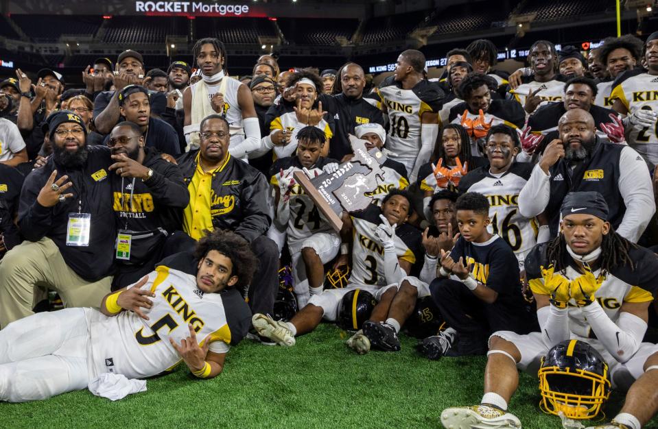 The Detroit King football team huddles together for a group picture after defeating Muskegon  56-27 during the Division 3 high school football finals at Ford Field in Detroit on Saturday, Nov. 26, 2022.