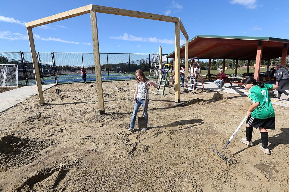 Ella Boshans, 12, and Kayla Budd, 11, of Troop 424 help spread sand by the new fire pit to help with Kayla's sister, Alyssa build her Eagle Scout project at the Marshfield Boys and Girls Club on Saturday, Oct 15, 2022. She was building a fire pit pergola at the Boys and Girls Club.