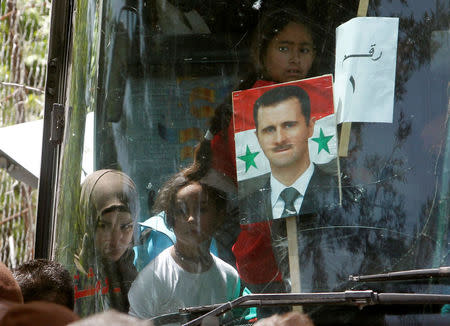 A picture of Syrian President Bashar al Assad is seen on a bus as Syrian refugees who fled to Lebanon go back to Syria from the southern village of Shebaa, Lebanon April 18, 2018. REUTERS/Aziz Taher