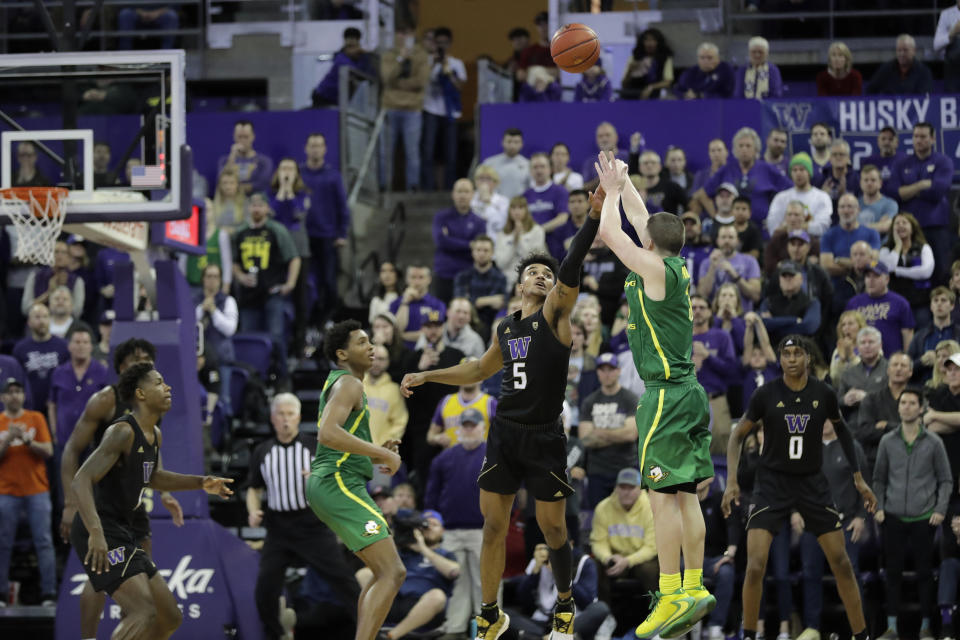 Oregon guard Payton Pritchard, right, shoots the game-winning 3-point basket as Washington guard Jamal Bey (5) tries for the block during overtime in an NCAA college basketball game, Saturday, Jan. 18, 2020, in Seattle. Oregon won 64-61 in overtime. (AP Photo/Ted S. Warren)