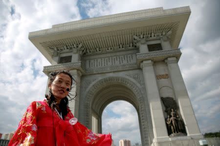 FILE PHOTO: A guide wearing a traditional dress speaks to visitors at the Arch of Triumph in Pyongyang, North Korea May 4, 2016. REUTERS/Damir Sagolj/File Photo