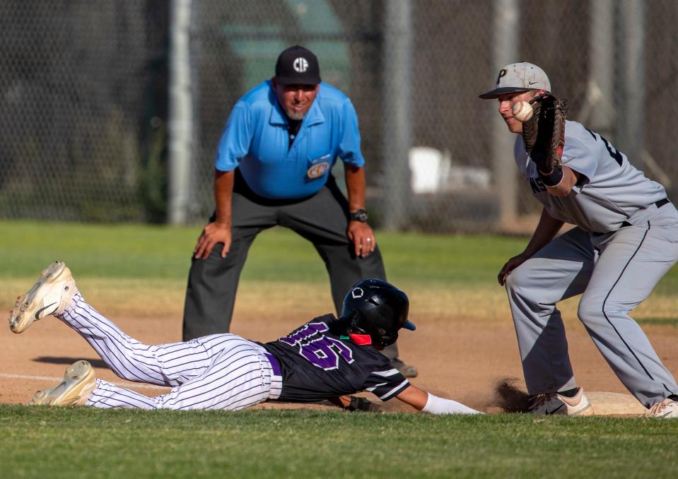Shadow Hills' Ernesto Ibarra (16) slides back into first as Peninsula's  Justin Rand (23) reaches for a catch on a pickoff attempt during their CIF-SS semifinal game at Shadow Hills High School in Indio, Calif., Tuesday, May 16, 2023. 