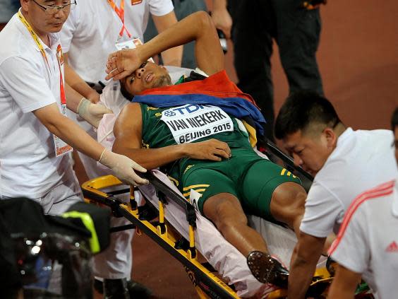 Wayde van Niekerk is wheeled off the track on a stretcher after winning 400m gold at the 2015 World Championships (Getty)