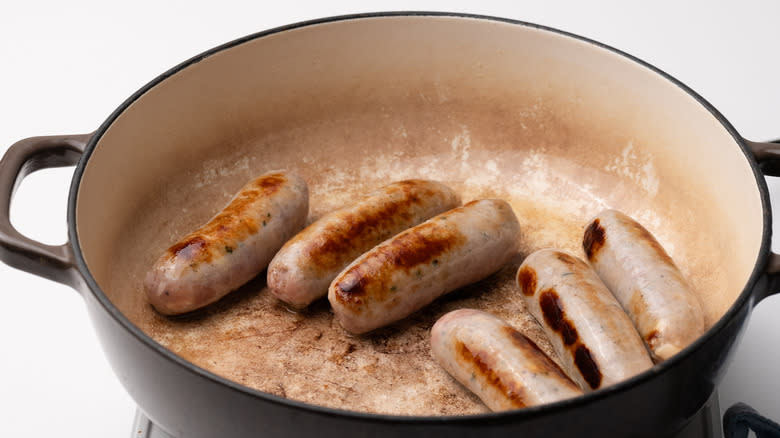 browning sausages in a pan
