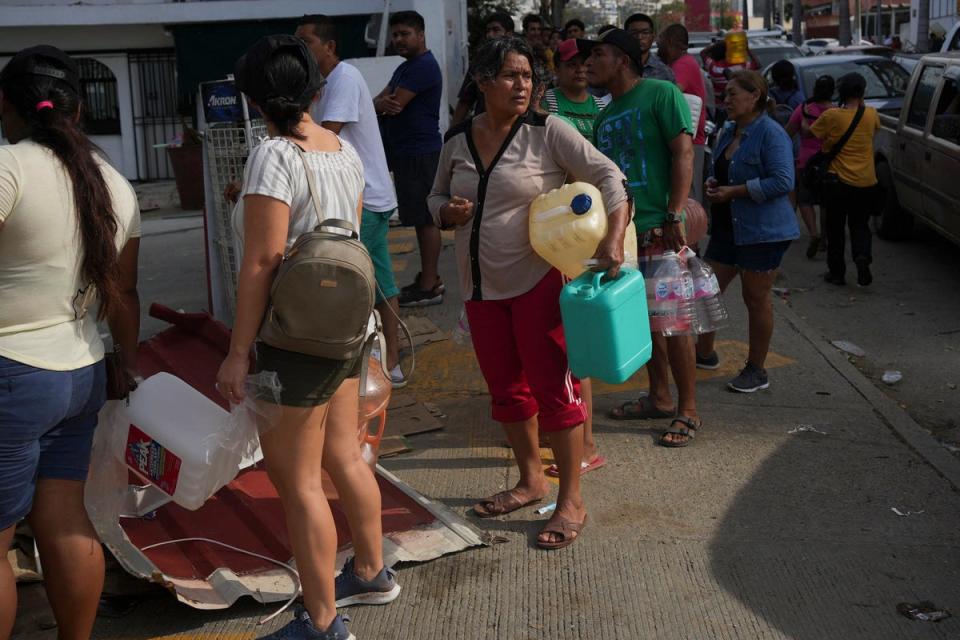 People wait in line with containers to buy gasoline in Acapulco (Copyright 2023 The Associated Press. All rights reserved)