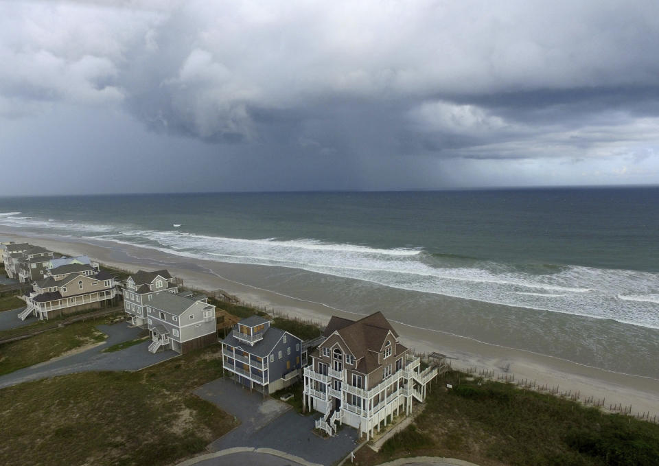 A storm front passes homes in North Topsail Beach, N.C., prior to Hurricane Florence moving toward the east coast on Wednesday, Sept. 12, 2018. (AP Photo/Tom Copeland)