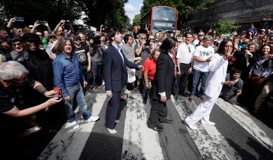 Beatles lookalikes traverse the iconic Abbey Road zebra crossing on the 50th anniversary of when the band walked across the stripes for their "Abbey Road" album cover. The studio of the same name is the focus of a new documentary, "If These Walls Could Sing."