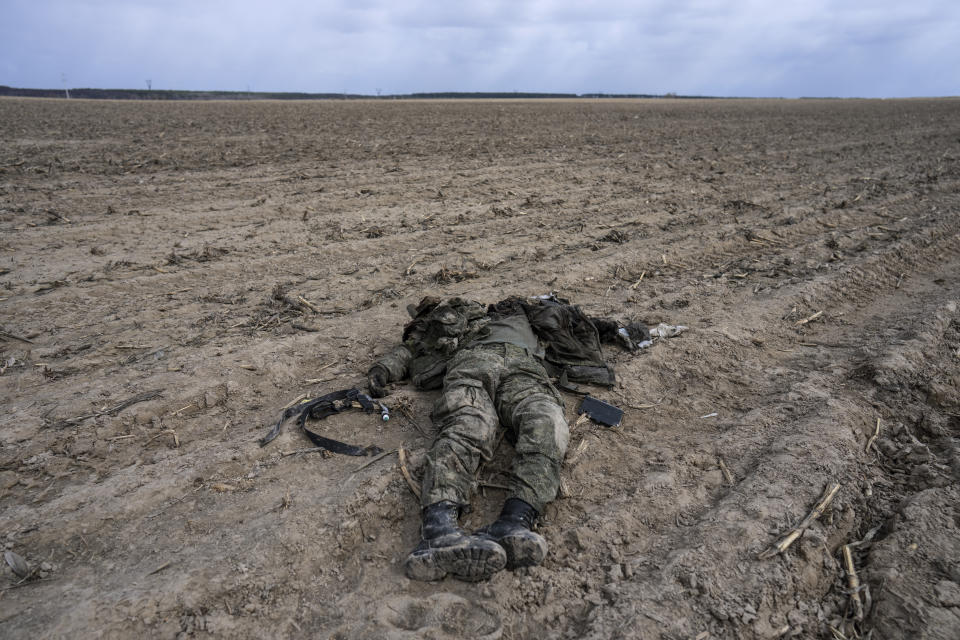 A Russian soldier killed during combats against the Ukrainian army lies in a corn field in Sytnyaky on the outskirts of Kyiv, Ukraine, Sunday, March 27, 2022. (AP Photo/Rodrigo Abd)