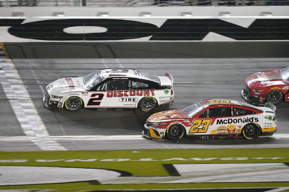 Austin Cindric (2) crosses the finish line ahead of Bubba Wallace (23) to win the the NASCAR Daytona 500 auto race at Daytona International Speedway, Sunday, Feb. 20, 2022, in Daytona Beach, Fla. (AP Photo/John Raoux)