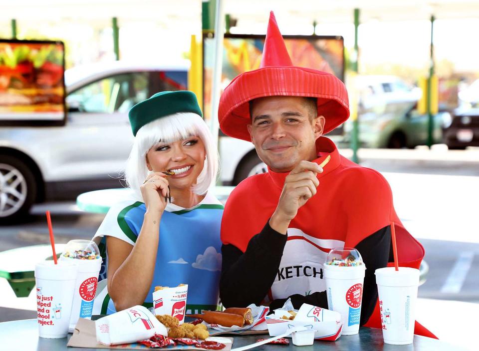 <p>Sara Jaye/Getty</p> Sarah Hyland and Wells Adams, in costume as Seemingly Ranch and Ketchup, Kick off Halloween at SONIC with the New Trick or Treat Blast Desserts at SONIC Drive-In Restaurant on October 16, 2023 in Duarte, California. 