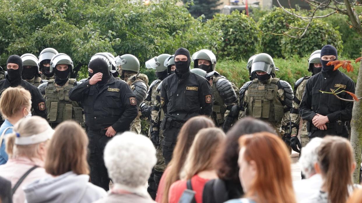 Demonstranten und Einsatzkräfte der Sonderpolizei OMON stehen sich am Unabhängigkeitsplatz in Minsk gegenüber.