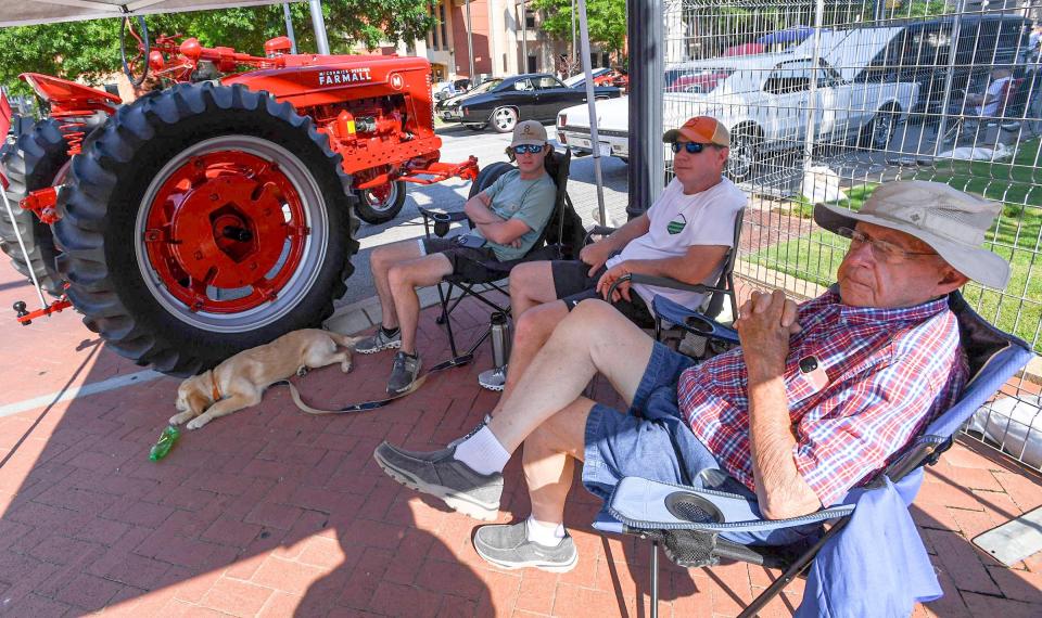 Pat Carpenter, right, owner of the 1942 Farmall M, who inherited the tractor from his late father Alton Carpenter, as he sits with his son Trent and grandson Andrew at the Main Street Program's 24th annual Piedmont Natural Gas Day B4 Father's Day Car Show in Anderson, S.C. Saturday, June 15, 2024. 