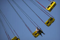 A woman wearing a face mask to protect against the coronavirus rides an amusement park ride at a public park in Beijing, Saturday, Oct. 24, 2020. With the outbreak of COVID-19 largely under control within China's borders, the routines of normal daily life have begun to return for its citizens. (AP Photo/Mark Schiefelbein)