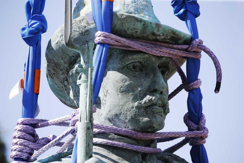 FILE - This Wednesday July 8, 2020, file photo shows The Confederate Soldiers & Sailors Monument secured by lifting straps as it is removed from Libby Hill Park in Richmond, Va. Devon Henry, whose company handled the summer removals of Richmond's Confederate monuments, spoke with The Associated Press about navigating safety concerns for himself and his crew and previously unreported complexities of the project. (AP Photo/Steve Helber)