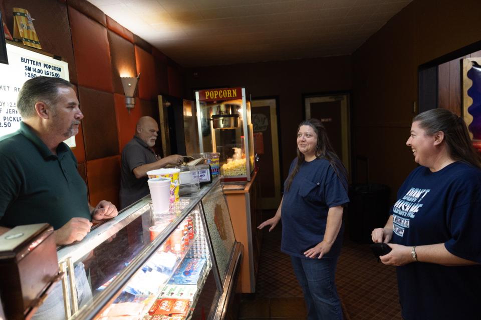 Owner Alan Bradshaw and Steve Oblad serve sisters Cheri Williams and Janette O’Driscoll, right to left, at the Ritz Theater in Tooele on June 9, 2023. Cheri and Janette have been coming to the theater together since 2012. | Ryan Sun, Deseret News