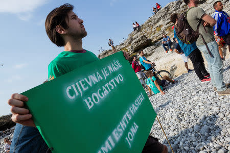 An environmental activist holds a banner reading "Cijevna is our wealth" in both Montenegrin and Albanian language during a protest in the dried out riverbed of Cijevna River in Dinosa village, near Tuzi, Montenegro October 20, 2018. REUTERS/Stevo Vasiljevic