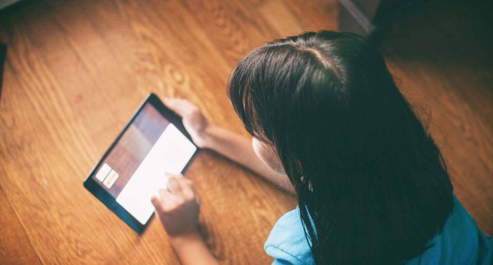 Little girl looks at iPad. 