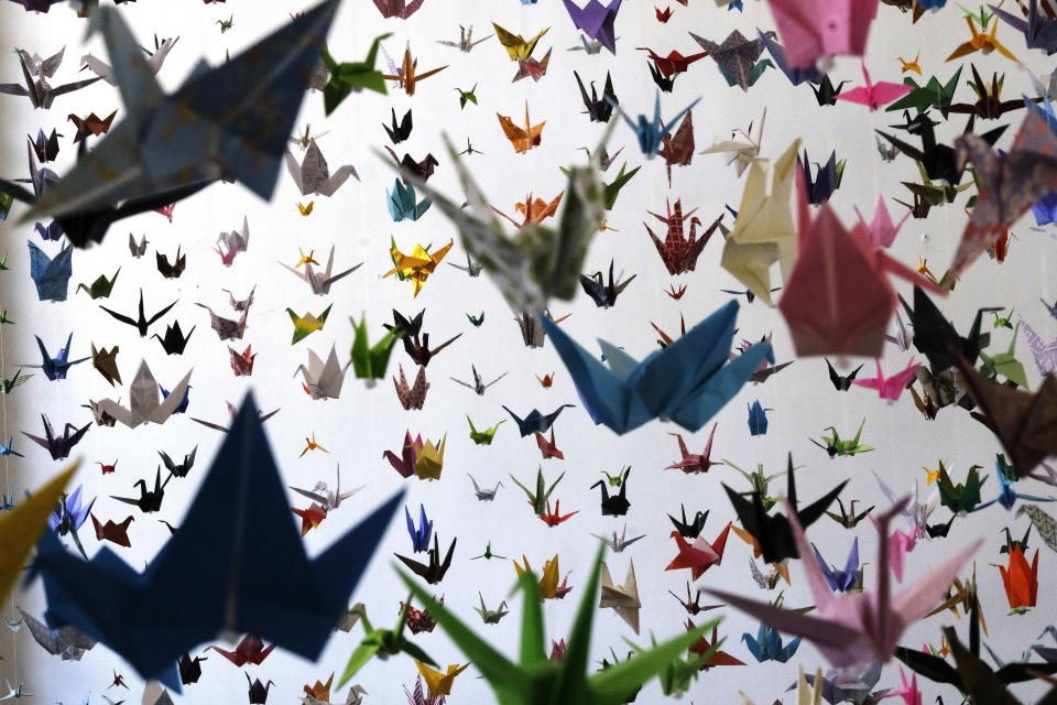 Origami paper cranes hang in the Matter Studio Gallery in Los Angeles during an exhibit for those who have died in the U.S. of COVID-19, on Tuesday, Aug. 11, 2020. Hundreds of origami now hang from the ceiling of Karla Funderburk’s Matter Studio with others sitting on tables and stacked in boxes waiting to be added to the sad reminder of the virus’ toll. (AP Photo/Richard Vogel)