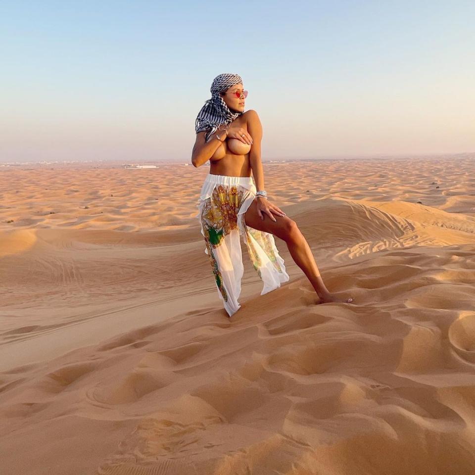 Luana Sandien holding her breasts in a Dubai desert