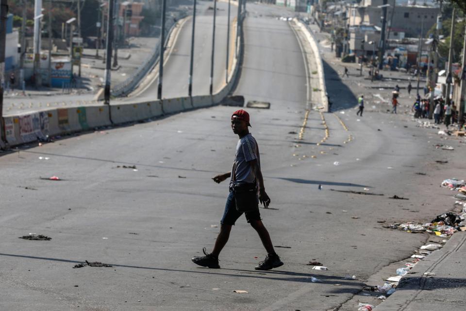 A pedestrian crosses a street free of traffic in Port-au-Prince, Haiti, Wednesday, March 13, 2024. (AP Photo/Odelyn Joseph)