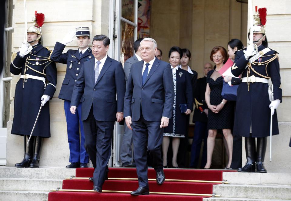 Chinese President Xi Jinping, centre left, and France's Prime Minister Jean Marc Ayrault, leave after a meeting in Paris, Thursday March 27, 2014. Deal-making and commemorations of a half-century of French diplomatic ties with Communist China were the order of business during Xi's three-day visit, part of his European tour. (AP Photo/Christophe Ena)