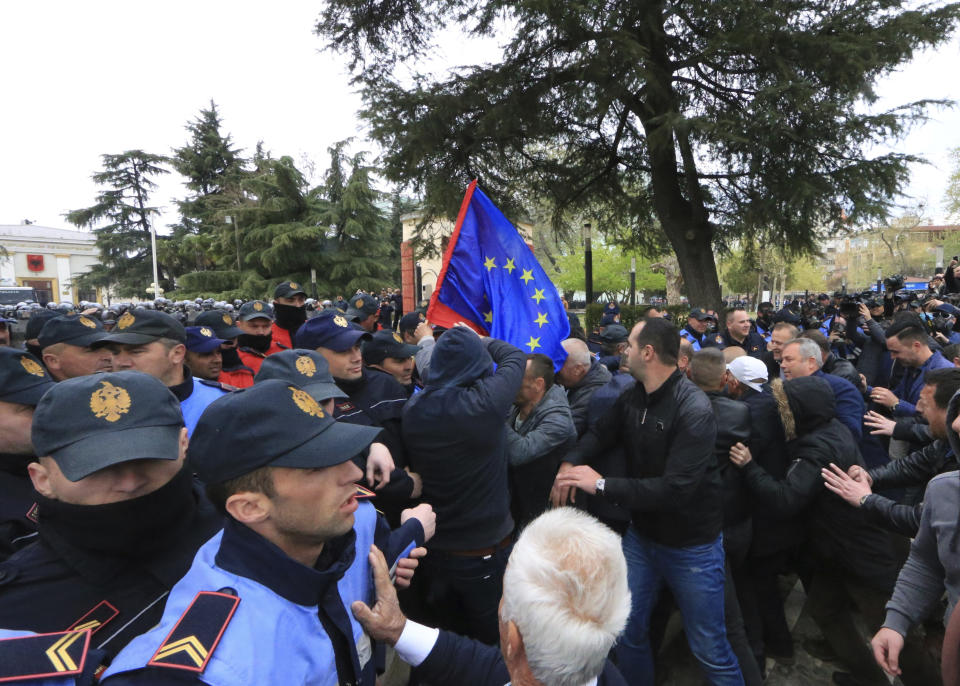 Protesters clash with police front of the Albanian parliament building in Tirana, on Thursday, March 28, 2019. Albanian opposition protesters have repeated attempts to enter the parliament by force in their protest asking for the government's resignation and an early election.(AP Photo/ Hektor Pustina)