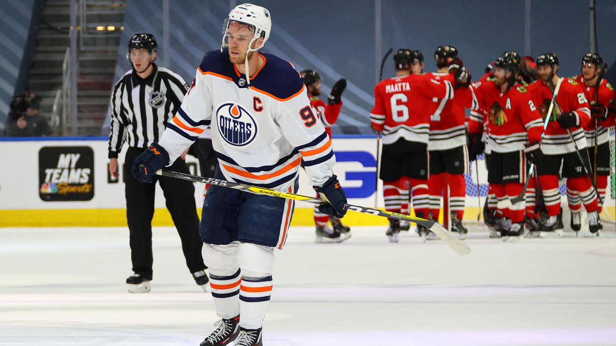 EDMONTON, ALBERTA - AUGUST 05: The Chicago Blackhawks congratulate one another on the ice as Connor McDavid #97 of the Edmonton Oilers looks on after Game Three of the Western Conference Qualification Round between the Edmonton Oilers and the Chicago Blackhawks at Rogers Place on August 05, 2020 in Edmonton, Alberta. The Blackhawks defeated the Oilers 4-3. (Photo by Dave Sandford/NHLI via Getty Images)