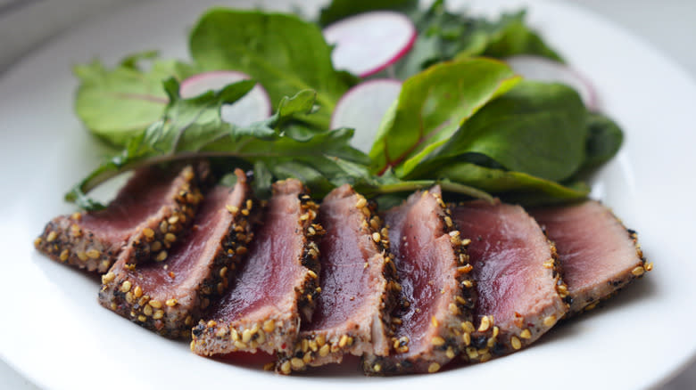 Tuna steak on a plate with greens