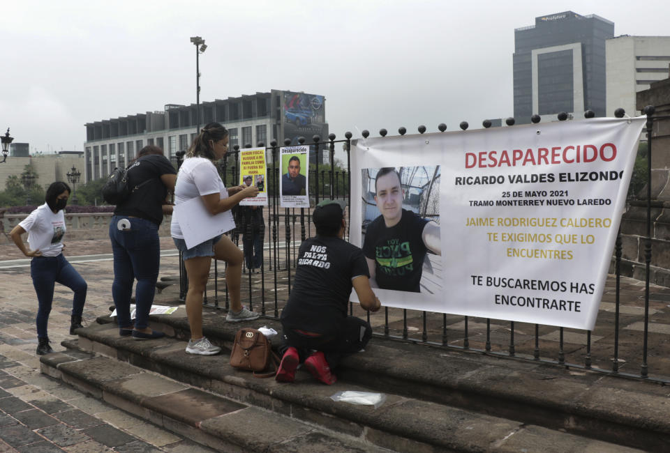 Family of Ricardo Valdes, who disappeared on the road on May 25, put up posters with their photography during a protest in Monterrey, Nuevo Leon state, Mexico, Thursday, June 24, 2021. As many as 50 people in Mexico are missing after they set off on simple highway trips between the industrial hub of Monterrey and the border city of Nuevo Laredo; relatives say they simply disappeared on the heavily traveled road, which has been dubbed 'the highway of death,' never to be seen again. (AP Photo/Roberto Martinez)