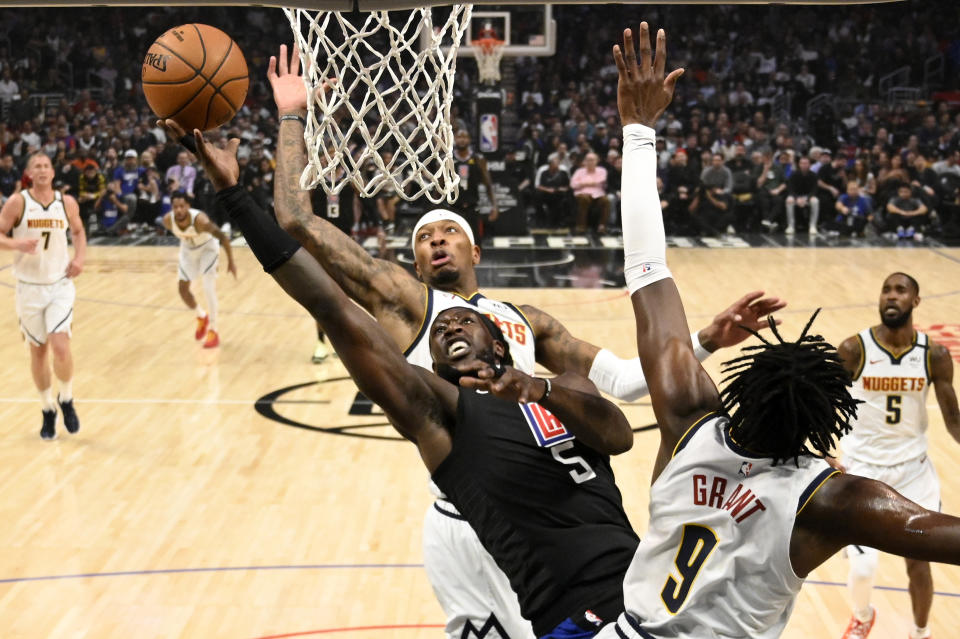 Los Angeles Clippers forward Montrezl Harrell, left, shoots as Denver Nuggets forward Torrey Craig, center, and forward Jerami Grant defend during the first half of an NBA basketball game Friday, Feb. 28, 2020, in Los Angeles. (AP Photo/Mark J. Terrill)