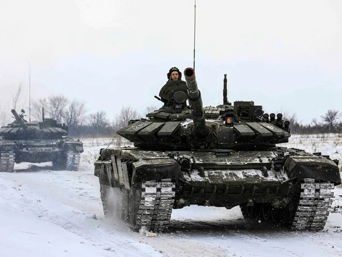 In this photo provided by the Russian Defense Ministry Press Service on Monday, Feb. 14, 2022, Russian tanks roll on the field during a military drills in Leningrad region, Russia.