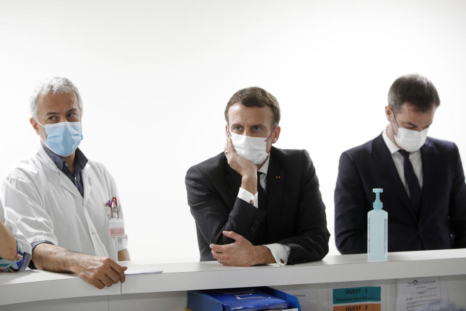 French President Emmanuel Macron, French Health Minister Olivier Veran, right, and Chief of Intensive Care Unit Dr. Jan Hayon listen to staff working in the intensive care ward of the Poissy/Saint-Germain-en-Laye hospital, near Paris, Wednesday, March 17, 2021. With the virus rebounding from Paris to Budapest and beyond, European governments that rushed to suspend use of AstraZeneca vaccines after reports of blood clots are realizing the far-reaching impact of the move. (Yoan Valat, Pool via AP)