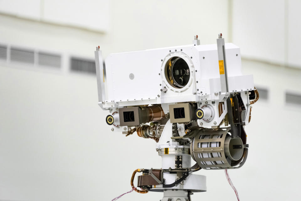 This July 23, 2019 photo made available by NASA shows the head of the Mars rover Perseverance's remote sensing mast which contains the SuperCam instrument in the large circular opening, two Mastcam-Z imagers in gray boxes, and next to those, the rover's two navigation cameras, at the Jet Propulsion Laboratory in Pasadena, Calif. The robotic vehicle will hunt for rocks containing biological signatures, if they exist. (NASA/JPL-Caltech via AP)