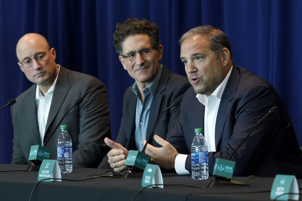 Victor Montagliani, right, CONCACAF president and FIFA vice president, speaks Monday, Nov. 1, 2021, in Seattle as Adrian Hanauer, center, owner of the MLS soccer Seattle Sounders, and Kasey Keller, left, former goalkeeper for the Sounders and the U.S. Men's National Team, look on during a news conference at Lumen Field. Montagliani was discussing taking part in an official visit of a FIFA delegation to Seattle, as organizers try to be selected as a host city for the FIFA World Cup in 2026. (AP Photo/Ted S. Warren)