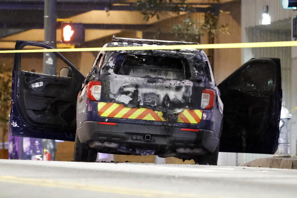 A burned police car sits on the street following a violent protest, Saturday, Jan. 21, 2023, in Atlanta, in the wake of the death of an environmental activist killed after authorities said the 26-year-old shot a state trooper. (AP Photo/Alex Slitz)