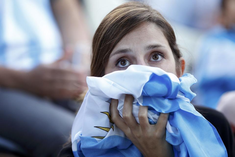 A fan of Argentina reacts while watching a broadcast of the 2014 World Cup final against Germany at the Argentine Embassy in Brasilia