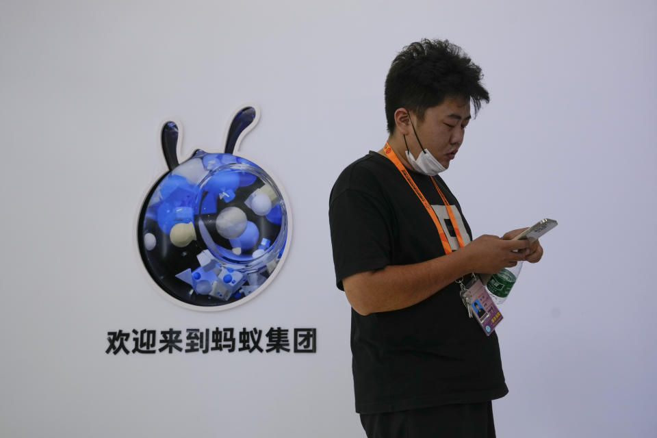 An exhibitor walks by the Ant Group booth during the China International Fair for Trade in Services (CIFTIS) at the Shougang venue in Beijing on Sept. 1, 2022. Chinese e-commerce giant Alibaba says it does not plan to sell any shares in its one-third shareholding in financial technology company Ant Group because it wants to retain its stake in an "important strategic partner." (AP Photo/Andy Wong)