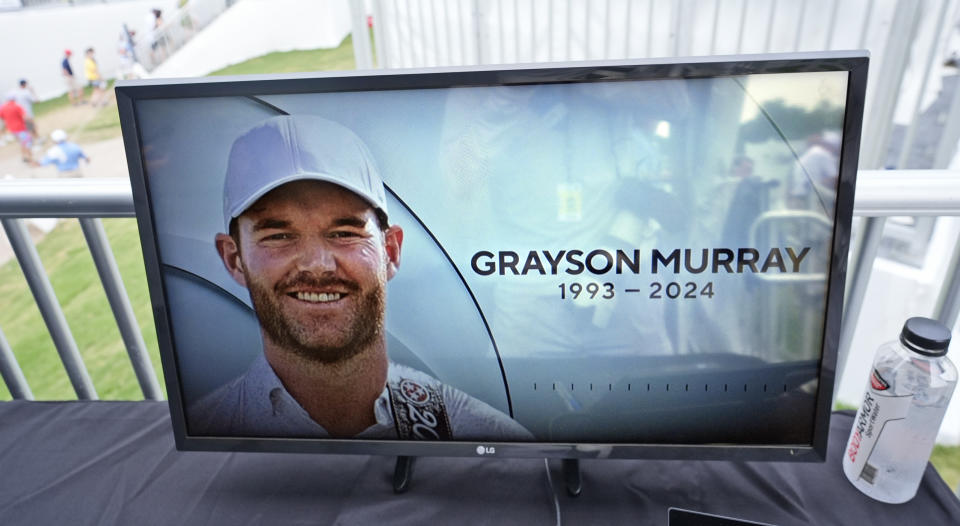 A golf television broadcast is played at the broadcast tent showing a photo of Grayson Murray during the third round of the Charles Schwab Challenge golf tournament at Colonial Country Club in Fort Worth, Texas, Saturday, May 25, 2024. Two-time PGA Tour winner Murray died Saturday morning at age 30, one day after he withdrew from the tournament. (AP Photo/LM Otero)