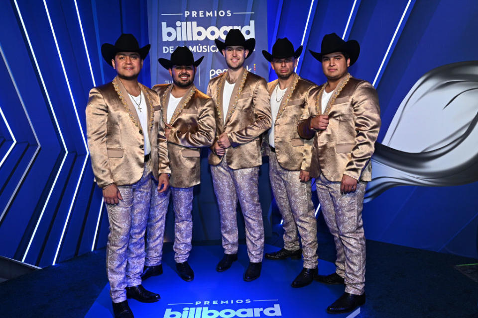 wearing matching pants and blazer jackets and cowboy hats