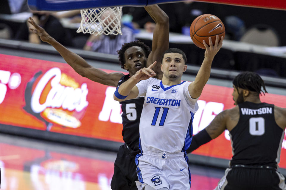 Creighton guard Marcus Zegarowski (11) makes a layup next to Providence forward Jimmy Nichols Jr. (5) during the first half of an NCAA college basketball game Wednesday, Jan. 20, 2021, in Omaha, Neb. (AP Photo/John Peterson)