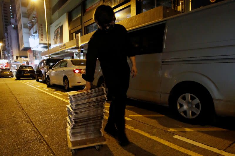 Supporter of Apple Daily newspaper wheels a stack of the June 18 edition he purchased from a newspaper seller in Hong Kong