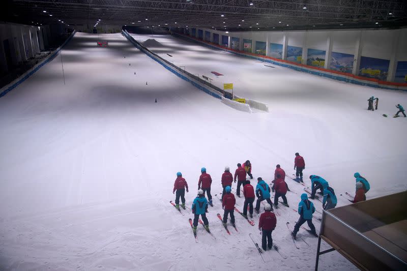 People warm up inside an indoor ski park at Qiaobo Ice and Snow World in Shaoxing