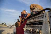 Syrians fleeing Turkish advance arrive to the town of Tal Tamr in north Syria, Monday, Oct. 14, 2019. Syrian government troops moved into towns and villages in northern Syria on Monday, setting up a potential clash with Turkish-led forces advancing in the area as long-standing alliances in the region begin to shift or crumble following the pullback of U.S. forces. (AP Photo/Baderkhan Ahmad)