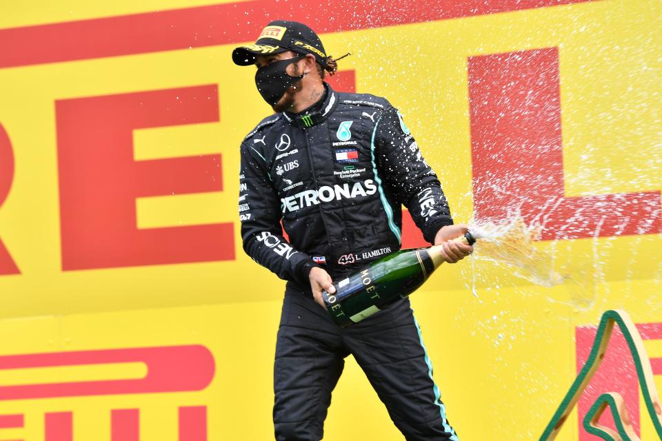 Mercedes' British driver Lewis Hamilton celebrates with champagne after the Formula One Styrian Grand Prix race on July 12, 2020 in Spielberg, Austria. (Photo by JOE KLAMAR / various sources / AFP) (Photo by JOE KLAMAR/AFP via Getty Images)