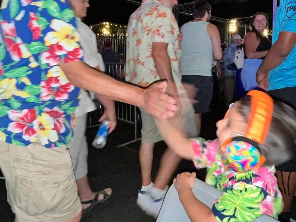 Alexavier Sandoval, 3, high fives another fan at the Beach Boys concert at the California State Fair on Friday, July 26, 2024.