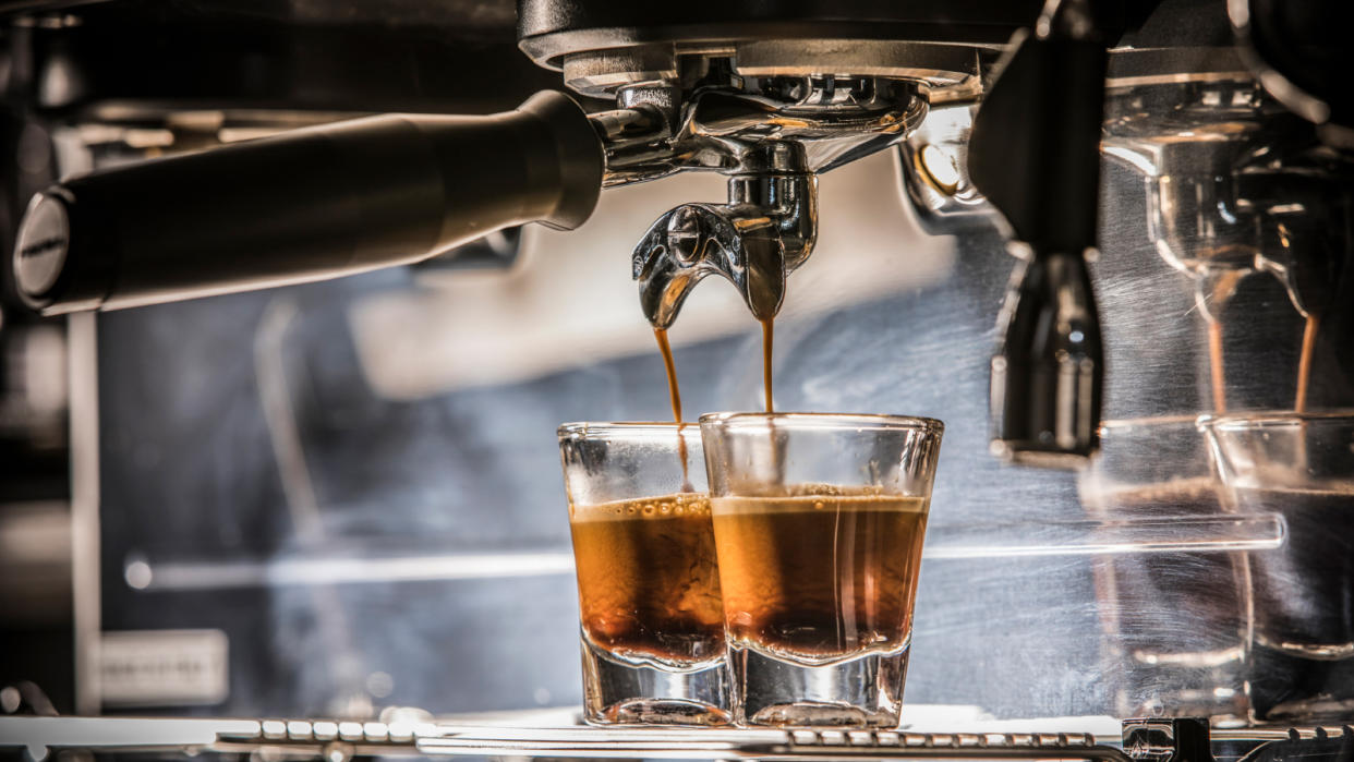  Espresso glasses beneath a coffee machine. 