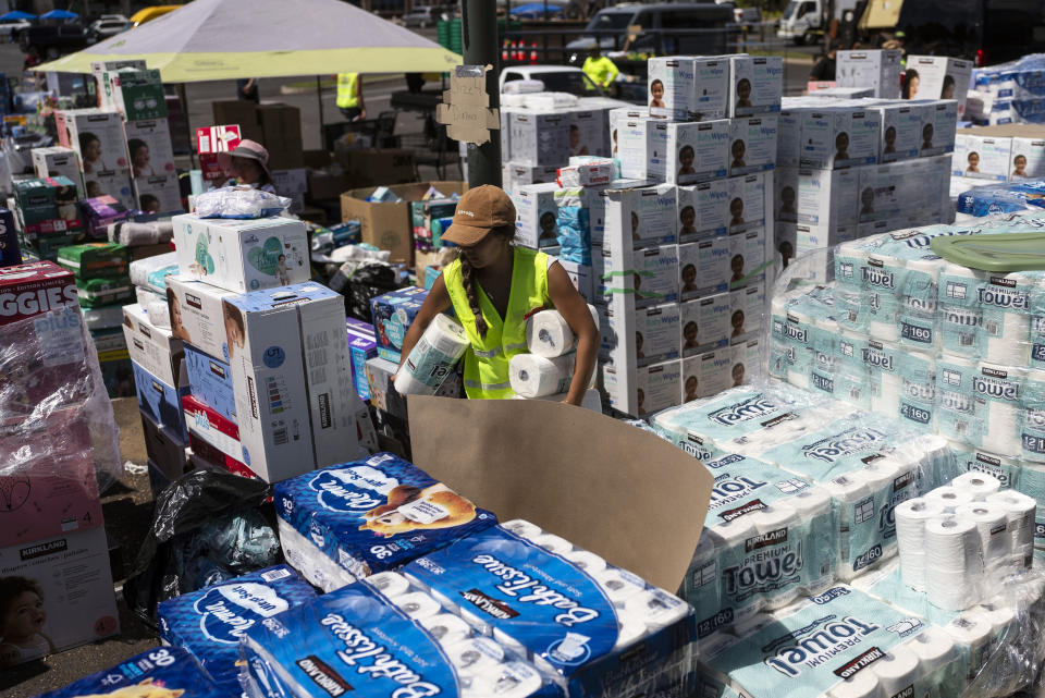 FILE - A volunteer works at a food and supply distribution center set up in the parking lot of a shopping mall in Lahaina, Hawaii, Wednesday, Aug. 16, 2023, after wildfire devastated parts of the Hawaiian island of Maui. (AP Photo/Jae C. Hong, File)