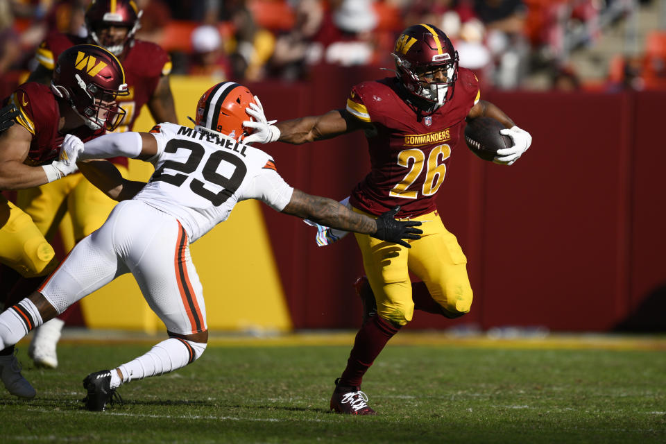 Washington Commanders running back Jeremy McNichols (26) runs past Cleveland Browns cornerback Cameron Mitchell (29) during the second half of an NFL football game in Landover, Md., Sunday, Oct. 6, 2024. (AP Photo/Nick Wass)